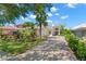 Paver driveway leads to a charming single-story home with tropical landscaping and a tile roof at 8708 Laurel N Dr, Pinellas Park, FL 33782