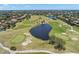 Aerial view of a lush green golf course surrounded by trees, ponds, and beautiful residential homes at 8708 Laurel N Dr, Pinellas Park, FL 33782
