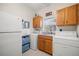 Well-equipped laundry room with tile flooring, washer, dryer, sink, and storage cabinets at 8708 Laurel N Dr, Pinellas Park, FL 33782