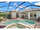 Screened-in pool and spa area with outdoor seating, brick patio, and lush landscaping for a relaxing backyard retreat at 8708 Laurel N Dr, Pinellas Park, FL 33782