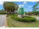 Landscaped sign for Bayou Club, a community with a water feature in the background, welcoming visitors at 8708 Laurel N Dr, Pinellas Park, FL 33782