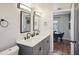 Bathroom featuring a double vanity, sleek fixtures, and a bright, modern design with a view to the dining room at 909 E 28Th Ave, Tampa, FL 33605
