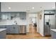 Updated kitchen with stainless steel dishwasher and gray cabinets, flowing into dining area at 909 E 28Th Ave, Tampa, FL 33605