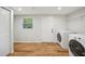 Bright laundry room featuring updated washer and dryer with closet space, and wood-look floors at 909 E 28Th Ave, Tampa, FL 33605