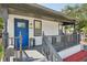 Inviting front porch features a bright blue door, gray railings and modern decor at 909 E 28Th Ave, Tampa, FL 33605