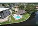 Aerial view of a home with a backyard pool, white fencing, and waterfront location at 9631 Oak Ne St, St Petersburg, FL 33702