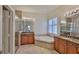 Bathroom with a soaking tub, granite counters, double sinks, and a glass shower at 16227 Cape Coral Dr, Wimauma, FL 33598