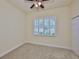 Bedroom with neutral carpet, ceiling fan, white trim, and a shuttered window at 16227 Cape Coral Dr, Wimauma, FL 33598