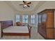 Inviting bedroom with a tray ceiling, chair, large window, and elegant armoire, perfect for rest and relaxation at 16227 Cape Coral Dr, Wimauma, FL 33598