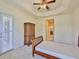 Bedroom boasts neutral carpet, wood furniture, shuttered doors, and decorative trey ceiling at 16227 Cape Coral Dr, Wimauma, FL 33598