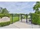 Fenced dog park entrance with signage, greenery, and a well-maintained interior at 16227 Cape Coral Dr, Wimauma, FL 33598