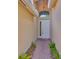 View of a front door with sidelight and an arched window above, brick walkway and manicured plants at 16227 Cape Coral Dr, Wimauma, FL 33598