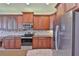 Modern kitchen with stainless steel appliances, wooden cabinets, and stylish tile backsplash at 16227 Cape Coral Dr, Wimauma, FL 33598