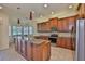Open kitchen featuring an island with granite countertops, stainless appliances, and ample cabinet space at 16227 Cape Coral Dr, Wimauma, FL 33598