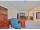 Well-appointed office featuring custom wood built-ins, a spacious desk, and a comfortable chair for a productive workspace at 16227 Cape Coral Dr, Wimauma, FL 33598