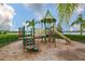 Community playground for with a slide and climbing structures on a mulched surface near a lake at 16227 Cape Coral Dr, Wimauma, FL 33598