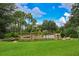 Scenic view of a community pond with a rock waterfall and lush landscaping, perfect for relaxation at 16227 Cape Coral Dr, Wimauma, FL 33598