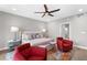 Bright bedroom with water views, ceiling fan, and sitting area with red chairs at 1 Beach Se Dr # 1902, St Petersburg, FL 33701