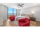Bright bedroom features water views from large window and stylish decor with two plush red chairs at 1 Beach Se Dr # 1902, St Petersburg, FL 33701