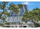 Exterior view of a modern high-rise condominium building with lush trees at 1 Beach Se Dr # 1902, St Petersburg, FL 33701