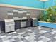 Outdoor grilling station with stainless steel grills, a sink, and stylish tile work at 1 Beach Se Dr # 1902, St Petersburg, FL 33701