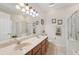 Well-lit bathroom features a dual-sink vanity with updated fixtures and a framed mirror and framed art above it at 10263 Devonshire Lake Dr, Tampa, FL 33647