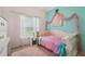 Cozy bedroom with a decorative pink canopy over the bed and large window letting in plenty of natural light at 10263 Devonshire Lake Dr, Tampa, FL 33647