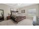 Serene main bedroom features a dark wood bed frame and neutral walls, creating a peaceful and inviting atmosphere at 10263 Devonshire Lake Dr, Tampa, FL 33647