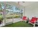 Relaxing sunroom with rocking chairs and a view of the backyard pond, ideal for enjoying the outdoors at 10263 Devonshire Lake Dr, Tampa, FL 33647