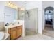 Bright bathroom featuring a walk-in shower and vanity with a view to the main bedroom at 10713 Shady Preserve Dr, Riverview, FL 33579