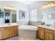 Bright bathroom featuring double vanities, soaking tub and a large window at 10713 Shady Preserve Dr, Riverview, FL 33579