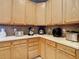 Functional kitchen area with wood cabinets, a tiled backsplash, and a white countertop for ample space at 10713 Shady Preserve Dr, Riverview, FL 33579