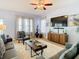 Comfortable living room with large windows, a ceiling fan, and a modern entertainment center at 10713 Shady Preserve Dr, Riverview, FL 33579