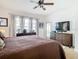Cozy main bedroom with a ceiling fan, access to the balcony, and dark wood furniture at 10713 Shady Preserve Dr, Riverview, FL 33579