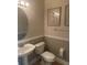 Cozy half bath with pedestal sink, framed mirror, and beach-themed wall art at 10713 Shady Preserve Dr, Riverview, FL 33579