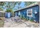 Exterior view of home showcasing the backyard patio with table and lush landscaping at 1115 45Th N St, St Petersburg, FL 33713