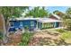Backyard with a patio featuring a table and chairs, lush plants and screened room at 1115 45Th N St, St Petersburg, FL 33713
