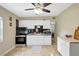 A well lit kitchen with white cabinets, subway tile backsplash, tile floor, and modern appliances at 1115 45Th N St, St Petersburg, FL 33713