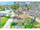 View of the charming home, showcasing mature trees and a well-manicured lawn, enveloped in natural beauty at 112 11Th Ave, Indian Rocks Beach, FL 33785