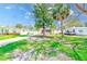 Exterior view of the house, featuring the front yard with lush greenery and a long driveway at 112 11Th Ave, Indian Rocks Beach, FL 33785