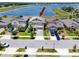 Aerial view of two-story gray home with manicured lawn and lake view at 11320 Chilly Water Ct, Riverview, FL 33569