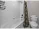 Bathroom featuring a tub with a shower, white tile surround and modern fixtures at 11320 Chilly Water Ct, Riverview, FL 33569