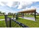 Community dog park with shaded seating, play area, and waste station, surrounded by green space and walking paths at 11320 Chilly Water Ct, Riverview, FL 33569