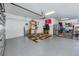 Spacious garage featuring an epoxy floor, overhead storage, and ample shelving at 11320 Chilly Water Ct, Riverview, FL 33569