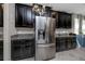 Updated kitchen showcasing stainless steel refrigerator and dark cabinets with granite countertops at 11320 Chilly Water Ct, Riverview, FL 33569