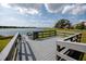 Community lake access featuring a gray wooden deck, stairs and railing and calm blue water view at 11320 Chilly Water Ct, Riverview, FL 33569