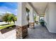 Inviting covered front porch with stone columns and a brick paver walkway at 11320 Chilly Water Ct, Riverview, FL 33569