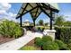 A covered seating area with Adirondack chairs, lush greenery, and a well-maintained landscape at 11320 Chilly Water Ct, Riverview, FL 33569