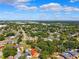 An aerial view of a lush residential neighborhood with green trees and colorful rooftops under a sunny, blue sky at 11510 92Nd Way, Largo, FL 33773