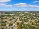 An aerial view of a suburban neighborhood with tree-lined streets under a bright blue sky with fluffy white clouds at 11510 92Nd Way, Largo, FL 33773